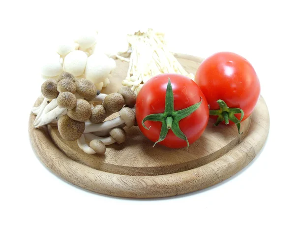 Tomate et champignons sur planche à découper en bois — Photo