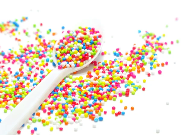 Perles de sucre colorées dans une cuillère blanche — Photo