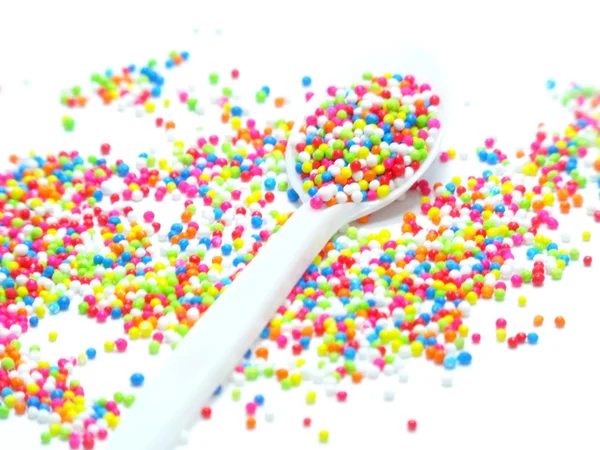 Perlas de azúcar de colores en cuchara blanca — Foto de Stock