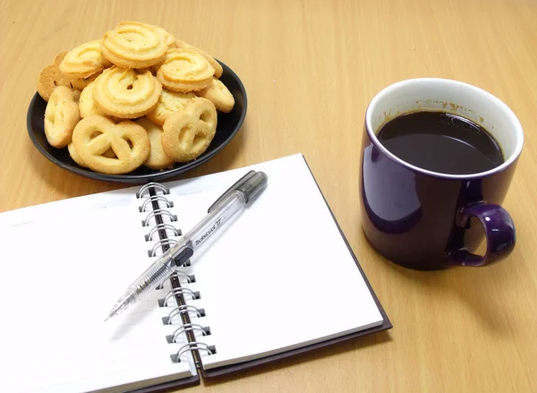 Coffee cup with sweet cookie notebook on woodle palette — Stock Photo, Image
