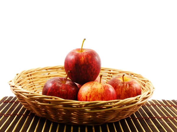 Rode appel in rieten mand op witte achtergrond — Stockfoto