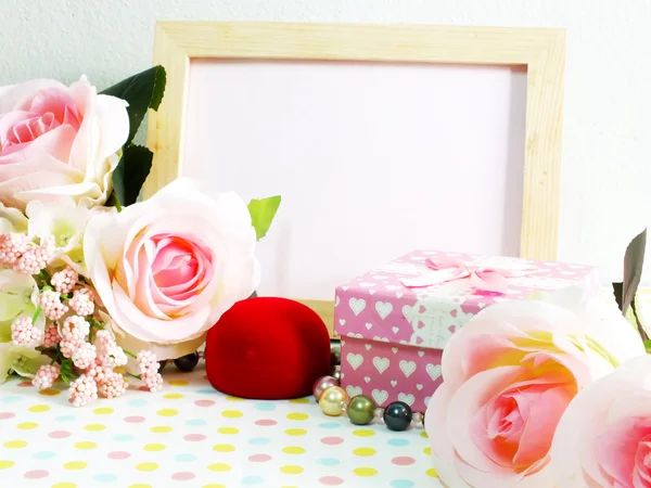 Moldura de madeira de foto em branco com rosas rosa e caixa de presente em flor doce — Fotografia de Stock