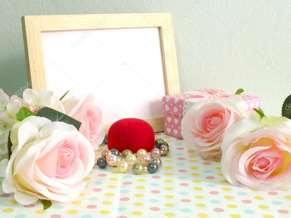 Blank photo wood frame with pink roses and gift box on sweet flower