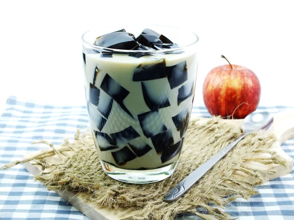 Thé au lait avec gelée noire en verre clair sur fond blanc — Photo