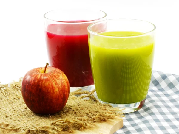 Pomme rouge et jus tropicaux dans des verres — Photo