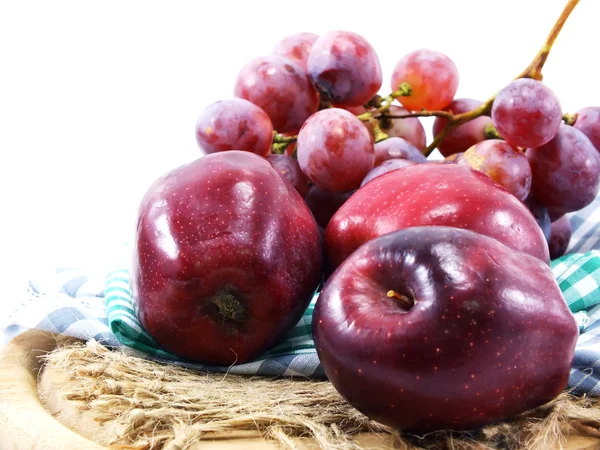 Rote Trauben und rote Äpfel auf Tischdecke — Stockfoto