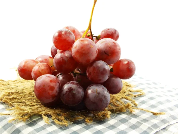 Uvas vermelhas e maçãs vermelhas na toalha de mesa — Fotografia de Stock