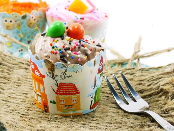 Nahaufnahme von Cupcake im süßen Pappbecher auf weißem Hintergrund — Stockfoto