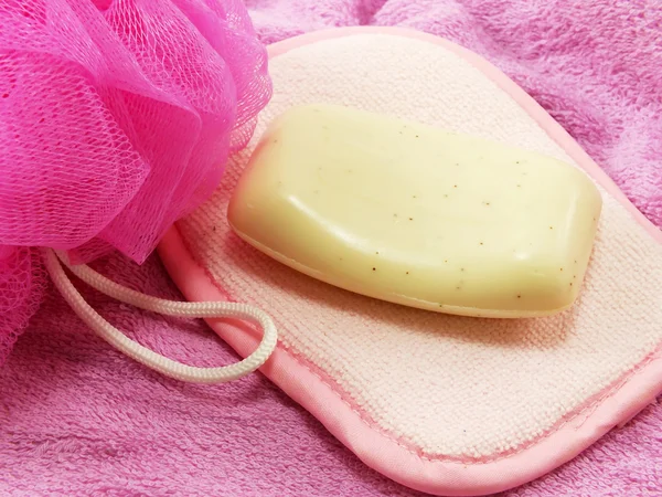 Pembe havlu ve banyo beyaz sabunla puf — Stok fotoğraf