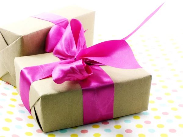 Caja de regalo con lazo rosa sobre fondo de lunares dulces —  Fotos de Stock