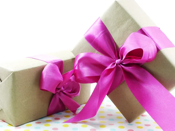 Подарункова коробка з рожевим бантом на солодкому фоні — стокове фото