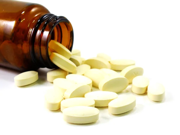 Botella píldora de la prescripción derramando pastillas en la superficie aislada sobre un fondo blanco — Foto de Stock