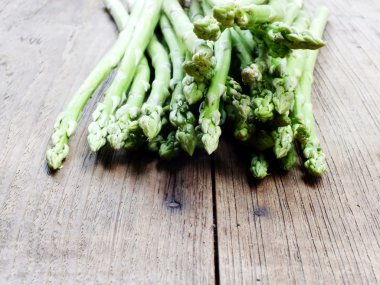 ahşap masa zemin üzerine yeşil ham kuşkonmaz