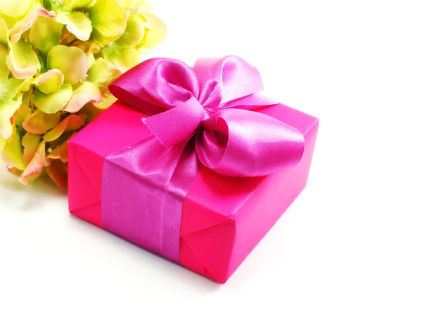 Рожевий подарунок на білому тлі зі стрічкою і красивою квіткою — стокове фото