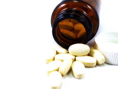 Reçeteli ilaç şişe hap beyaz bir arka plan üzerinde izole yüzey üzerine dökülüp