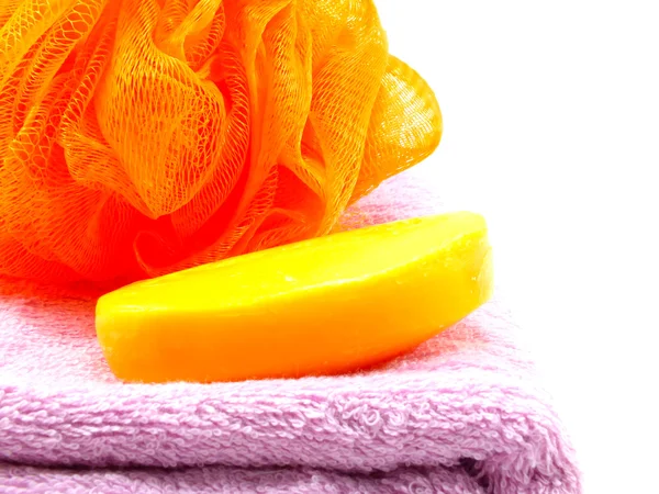 Plastic bath puff and towel on white background — Stock Photo, Image