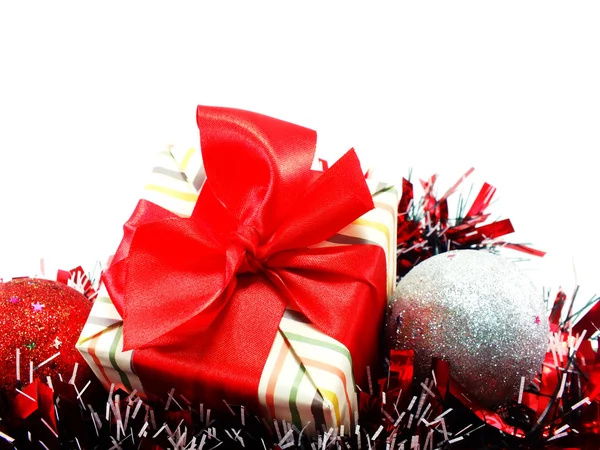 Regalo caja regalo con decoraciones de cinta roja con fondo de chistmas de oropel rojo y blanco —  Fotos de Stock