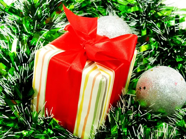 Pudełko z czerwoną wstążką dekoracje z biało -czerwone tło Blichtr Boże Narodzenie — Zdjęcie stockowe