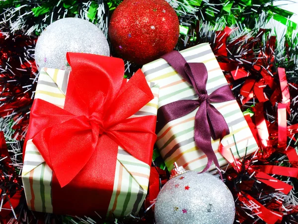 Regalo caja regalo con decoraciones de cinta roja con fondo de Navidad de oropel rojo y blanco —  Fotos de Stock