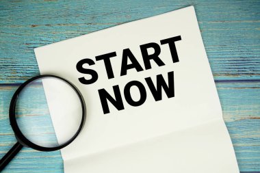 Başlangıç Şimdi not defterine yazılan ve büyüteç düzlüğü tahta zemin üzerinde uzanan metin