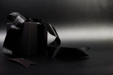 Siyah arkaplanda siyah kurdeleli hediye kutusu