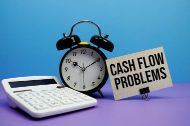 Mavi ve mor arkaplan üzerinde hesap makinesi ve alarm saati olan nakit akışı sorunları metni