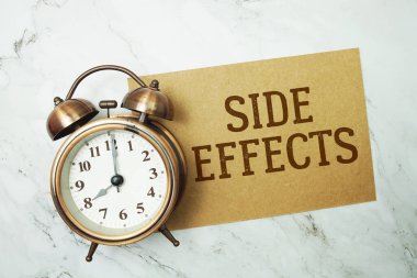 Kağıt kartta, mermer zemin üzerinde alarmlı saat ile yazılmış metni yan etkiler