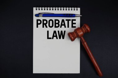 Vasiyet Kanunu metni siyah arkaplanda tokmak ile not defterine yazıldı