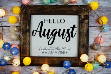 Merhaba ağustos metni ve ahşap zemin üzerinde LED pamuk topu süslemesi