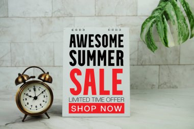 Mermer zemin üzerinde alarm saati olan yaz indirimi metni