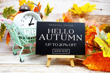 Sonbahar İndirimi% 20 indirimli Alarm saati ve ahşap arka planda akçaağaç yaprağı süslemeli Özel Teklif metni