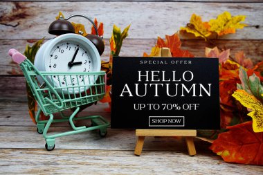 Sonbahar İndirimi% 70 indirimli Alarm saati ve ahşap arka planda akçaağaç yaprağı süslemeli Özel Teklif metni