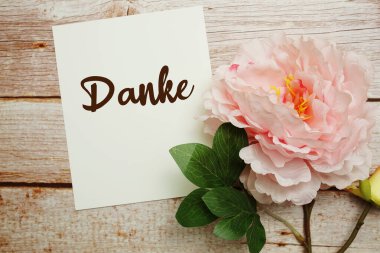 Ahşap arkaplanda çiçek buketi olan teşekkür metni