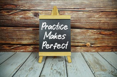 Ahşap sehpa, üzerinde beyaz bir yazı olan tahta bir tahtayı taşralı ahşap bir duvara ve açık renkli ahşap zemine karşı 