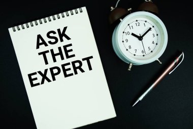 Not defterine kalem ve alarm saati ile yazılmış The Expert metnini sor