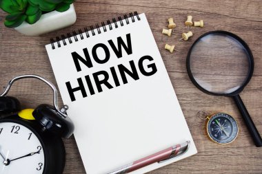 Alarm saati, pusula ve büyüteçle not defterine yazılan metin ahşap arka planda yatıyordu