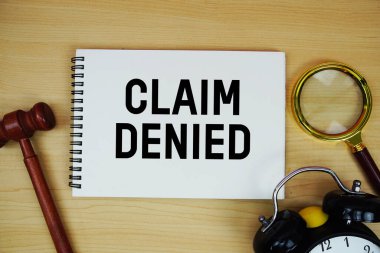 Not defterine kalem, alarm saati ve tahta arka planda yargıç tokmağı ile yazılan reddedilmiş metin