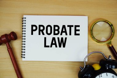 Vasiyetname not defterine kalem, alarm saati ve tahtadan arka planda yargıç tokmağıyla yazılmış.