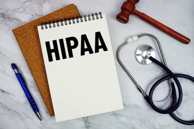 Not defterine steteskop ve mermer zemin üzerinde tokmak ile yazılmış HIPAA metni