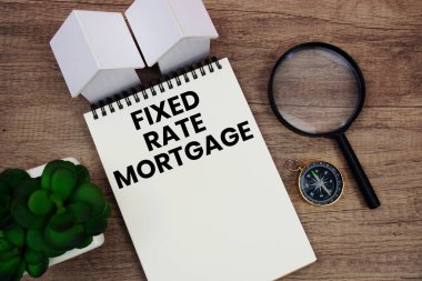 FRM Ev Modeli, büyüteç ve ahşap arka planda pusula içeren sabit oranda ipotek metni