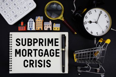 Kalem, hesap makinesi, büyüteç, saat, mini tramvay alışveriş arabası ve ev modeliyle çevrili 