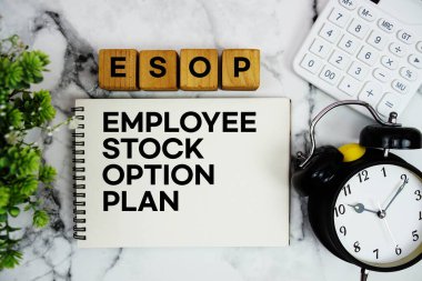 ESOP Personel Seçenek Planı metni, mermer zemin üzerinde hesap makinesi ve alarmlı saat