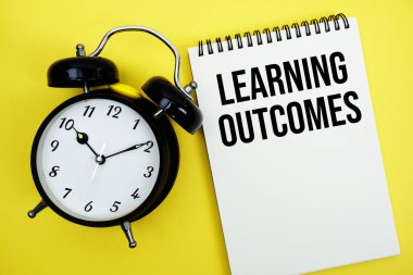 Alarm saati düz sarı arkaplan üzerinde uzanan Çıktılar metni öğreniliyor