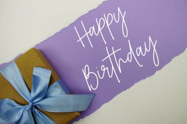 Mor zemin üzerinde hediye kutusu olan Mutlu Yıllar metni