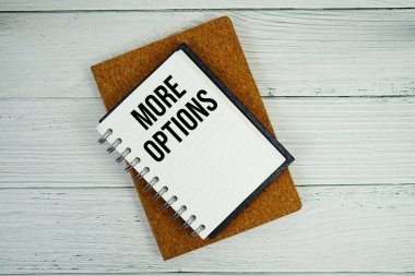 Not defterine yazılan daha fazla seçenek metni tahta arkaplanda yatıyordu