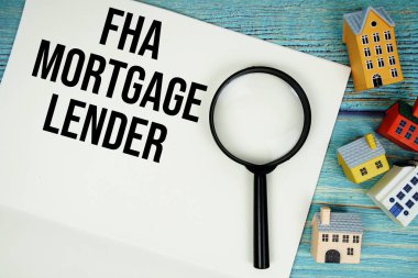 Tahta arka planda büyüteç ve ev modeli olan 