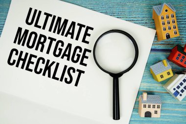 Tahta arka planda büyüteç ve ev modeli ile 