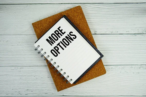 Not defterine yazılan daha fazla seçenek metni tahta arkaplanda yatıyordu