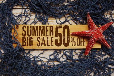 Yaz aylarında deniz yıldızı ve ahşap arka planda ağ ile süslenmiş ahşap tabelada% 50 indirim var.