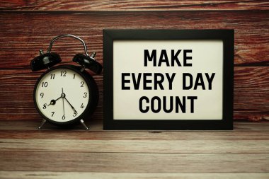 Ahşap zemin üzerinde alarm saati olan Her Gün Sayımı metni oluştur